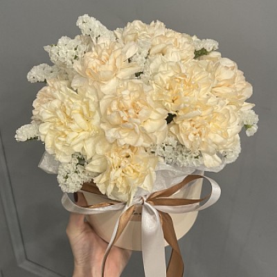 Букет в шляпной коробке из 15 персиковых гвоздик